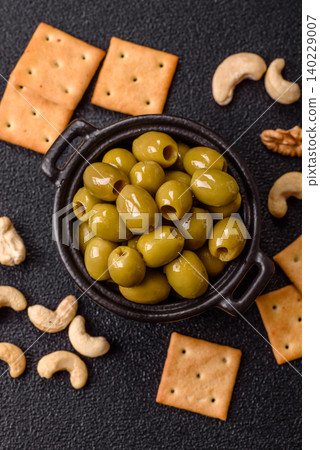 Whole green olives without pits in a bowl as an ingredient for cooking at home. Green olives Whole green olives without pits in a bowl as an ingredient for cooking at home. Green olives 140229007
