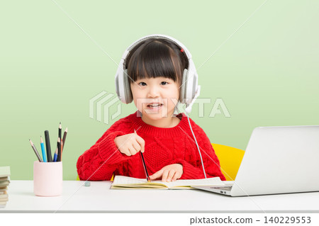 Asian little girl studying online with laptop and headset, interactive e-learning concept Asian little girl studying online with laptop and headset, interactive e-learning concept 140229553