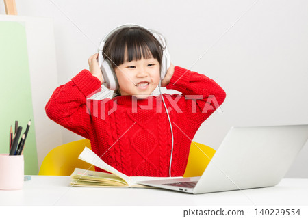 Asian little girl studying online with laptop and headset, interactive e-learning concept Asian little girl studying online with laptop and headset, interactive e-learning concept 140229554
