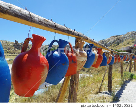 Colorful traditional ceramic water jars hanging under the blue sky of Cappadocia, Turkey. Colorful traditional ceramic water jars hanging under the blue sky of Cappadocia, Turkey. 140230521