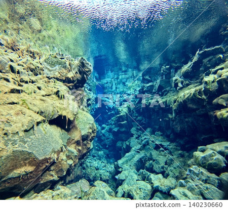 A scene of people enjoying scuba diving at Silfra Rift in Þingvellir National Park, Iceland. A scene of people enjoying scuba diving at Silfra Rift in Þingvellir National Park, Iceland. 140230660