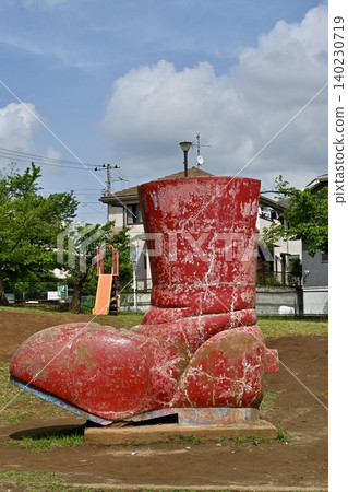 公園裡擺放著一個復古的紅色鞋子形狀的遊樂設施:昭和時代的懷舊氣息與日常景象。 公園裡擺放著一個復古的紅色鞋子形狀的遊樂設施:昭和時代的懷舊氣息與日常景象。 140230719