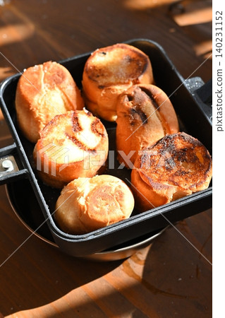 Delicious breakfast to enjoy while camping: Fragrant round bread baked in a camping pot. Outdoor cooking. Delicious breakfast to enjoy while camping: Fragrant round bread baked in a camping pot. Outdoor cooking. 140231152
