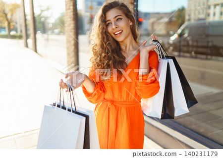 Young woman with shopping bags near mall. Summer Style. Shopping, lifestyle, sale concept. Young woman with shopping bags near mall. Summer Style. Shopping, lifestyle, sale concept. 140231179