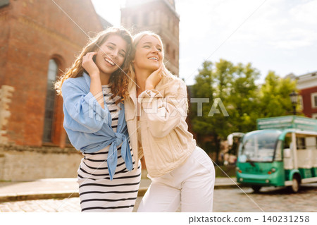 Female tourists in bright dress enjoys sights of city on sunny day. Concept of lifestyle, fashion. Female tourists in bright dress enjoys sights of city on sunny day. Concept of lifestyle, fashion. 140231258