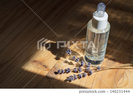 Clear Cosmetic Bottle with Lavender on Wood Clear Cosmetic Bottle with Lavender on Wood 140231444