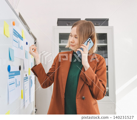Woman smiling to herself as she works in an office Woman smiling to herself as she works in an office 140231527