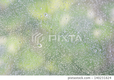 下雨天，一把透明的雨傘上掛滿了雨滴。 140231824