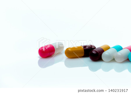 Multi-color antibiotic capsule pills on white background. Antibiotic drug resistance. Prescription drugs. Polypharmacy concept. Pharmacy drugstore product. Pharmaceutical industry. Capsule manufacture 140231917