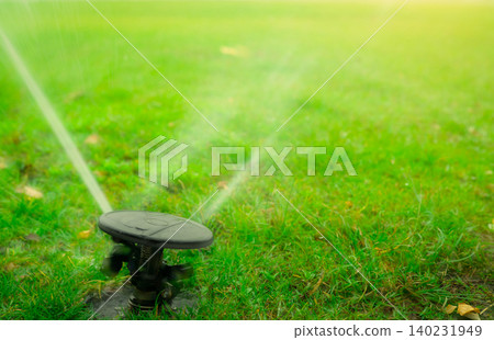 Automatic lawn sprinkler watering green grass. Garden, yard irrigation system watering lawn. Water saving or conservation from sprinkler system. Turf farm business. Sprinkler service and maintenance. 140231949