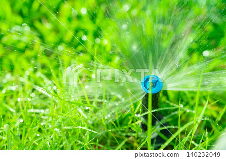 Automatic lawn sprinkler watering green grass. Sprinkler with automatic system. Garden irrigation system watering lawn. Water saving or water conservation from sprinkler system with adjustable head. Automatic lawn sprinkler watering green grass. Sprinkler with automatic system. Garden irrigation system watering lawn. Water saving or water conservation from sprinkler system with adjustable head. 140232049