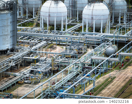 Industrial oil refinery and petrochemical plant with extensive steel pipelines and gas storage tanks. Infrastructure for the energy and fuel. Oil and gas refinery plant. Network of pipes and tanks. Industrial oil refinery and petrochemical plant with extensive steel pipelines and gas storage tanks. Infrastructure for the energy and fuel. Oil and gas refinery plant. Network of pipes and tanks. 140232216