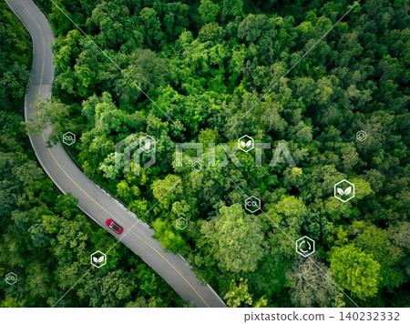Aerial drone view of red electric car on highway through green forest. Sustainable transport and carbon neutrality. Eco-friendly travel and emission reduction. CO2 reduction and EV battery efficiency. Aerial drone view of red electric car on highway through green forest. Sustainable transport and carbon neutrality. Eco-friendly travel and emission reduction. CO2 reduction and EV battery efficiency. 140232332