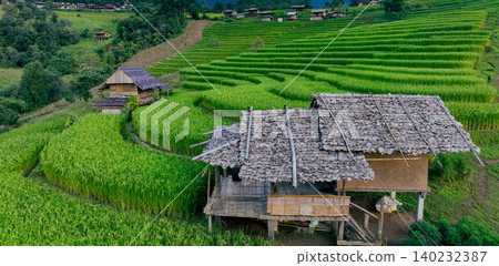 Landscape of green rice terraces and traditional huts in a village near Chiangmai, Thailand. Travel destinations. Beauty of terraced rice fields. Rural life and traditional farming practices in Asia. 140232387