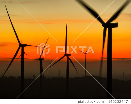 Wind farm field and sunset sky. Wind power. Sustainable, renewable energy. Wind turbines generate electricity. Sustainable development. Green technology for energy sustainability. Eco-friendly energy. 140232447