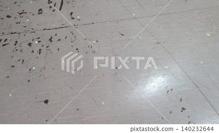 High angle view captures small glowing green laser dots projected over a textured dirty floor surface. Scattered light spots scatter across tiles, creating a unique abstract tech background template. High angle view captures small glowing green laser dots projected over a textured dirty floor surface. Scattered light spots scatter across tiles, creating a unique abstract tech background template. 140232644