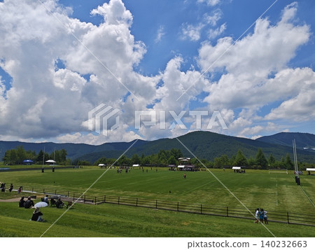 A rugby field on a plateau under a summer sky and towering cumulonimbus clouds. 140232663