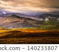 The overall scene depicts a wild, expansive landscape under a dynamic sky. 140233807