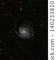 Grand spiral galaxy Pinwheel Galaxy M101 extends glowing arms from its bright core. Many scattered stars fill the surrounding dark deep space, presenting a vast cosmic view visible at night. 140233810
