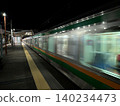 A limited express train passing a level crossing late at night. 140234473