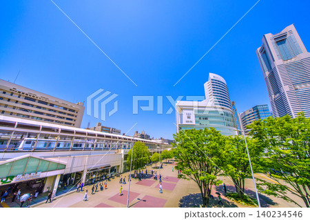 日本橫濱市的新都會景觀。夏日里，櫻木町車站、列車和橫濱地標塔沐浴在蔥鬱的綠意之中。 （8月18日） 140234546
