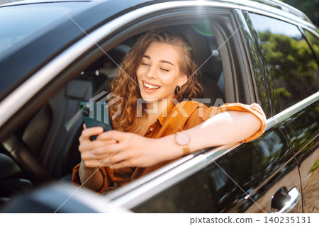 A young woman uses a mobile phone to navigate in the city, pay for parking. Business concept. A young woman uses a mobile phone to navigate in the city, pay for parking. Business concept. 140235131