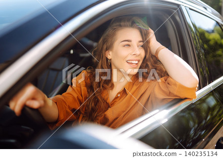 Emotional woman drives a car. The concept of fast movement, traveling by car. Emotional woman drives a car. The concept of fast movement, traveling by car. 140235134
