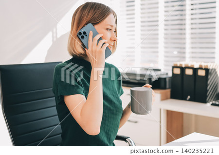 Happy female entrepreneur using smart phone in office. 140235221