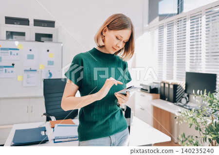 Closeup image of a businesswoman using mobile phone in office 140235240