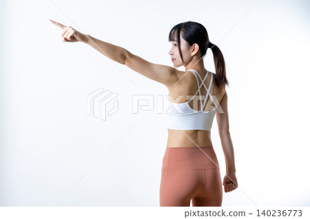 A fit and stylish woman who works out: confidence, goals, pointing, starting, leggings. A fit and stylish woman who works out: confidence, goals, pointing, starting, leggings. 140236773