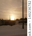 A beautiful, nostalgic sunset sky with the silhouettes of the setting sun and telephone poles. 140236782
