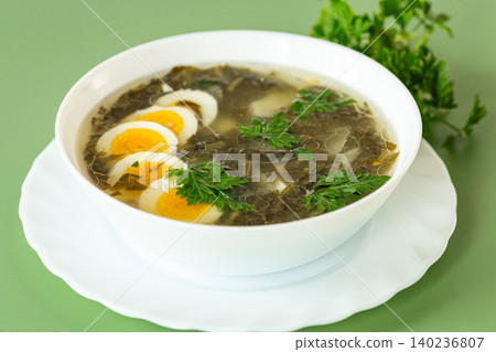 traditional green borscht with sorrel and eggs in a white plate traditional green borscht with sorrel and eggs in a white plate 140236807