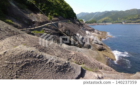A scenic walking trail leading to a massive rock face eroded by the rough waves of the Pacific Ocean. A scenic walking trail leading to a massive rock face eroded by the rough waves of the Pacific Ocean. 140237359