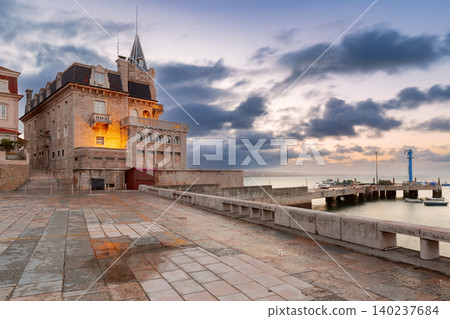 Santa Marta waterfront with the historic seafront building and harbor pier at dawn in Cascais, Portugal. Santa Marta waterfront with the historic seafront building and harbor pier at dawn in Cascais, Portugal. 140237684
