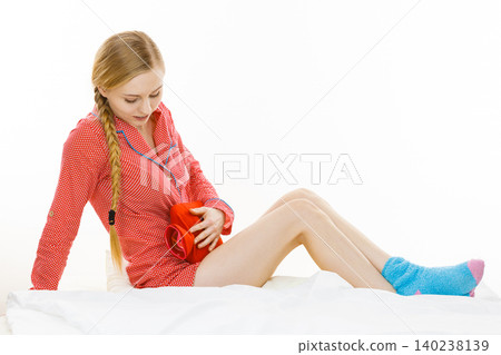Woman feeling stomach cramps lying on bed Woman feeling stomach cramps lying on bed 140238139