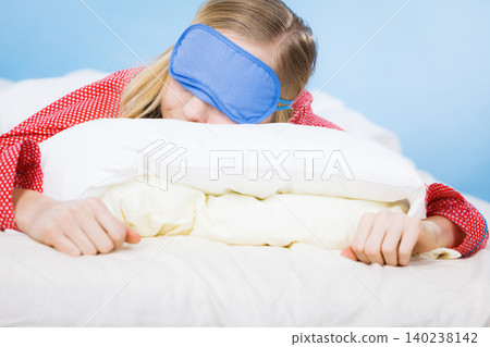 Young woman wearing sleeping eye band in bed Young woman wearing sleeping eye band in bed 140238142