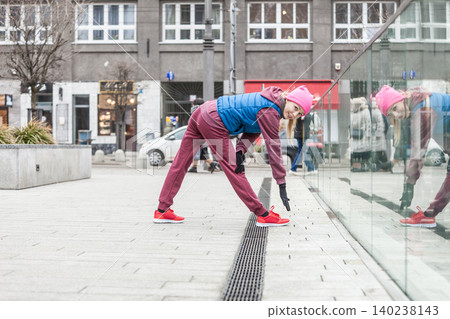 Sporty girl stretching outdoor on city street. Sporty girl stretching outdoor on city street. 140238143