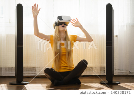 Girl wearing virtual reality goggles at home Girl wearing virtual reality goggles at home 140238171