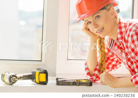 Woman with tools and helmet next to the window 140238238