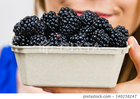 Girl holds blackberry fruits Girl holds blackberry fruits 140238247