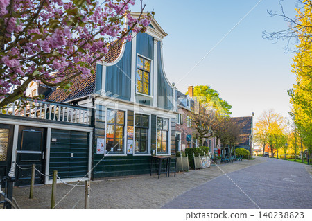 Traditional Dutch house with green facade and blooming cherry blossom tree along cozy cobblestone street Traditional Dutch house with green facade and blooming cherry blossom tree along cozy cobblestone street 140238823