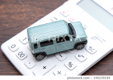 A car and a calculator placed on the desk A car and a calculator placed on the desk 140239195
