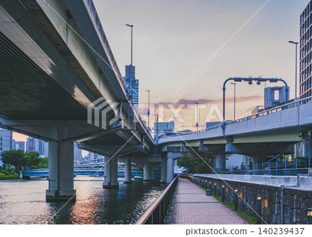The Hanshin Expressway viaduct stretches into the sunset sky, and the riverside promenade is visible. The Hanshin Expressway viaduct stretches into the sunset sky, and the riverside promenade is visible. 140239437