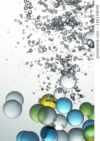 A background of colorful glass marbles and a large number of bubbles in the water. A background of colorful glass marbles and a large number of bubbles in the water. 140239646