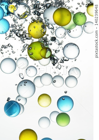 A background of colorful glass marbles and a large number of bubbles in the water. A background of colorful glass marbles and a large number of bubbles in the water. 140239648