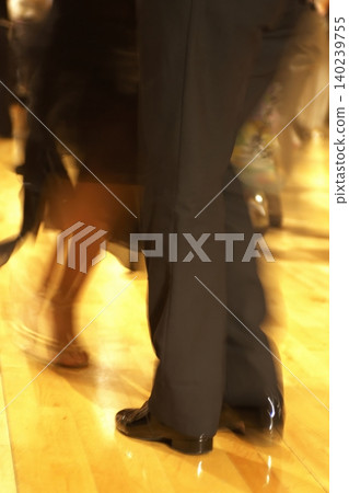 舞廳舞池中舞者翩翩起舞,舞者的雙腳在運動中呈現模糊效果。 舞廳舞池中舞者翩翩起舞,舞者的雙腳在運動中呈現模糊效果。 140239755