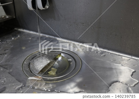 Kitchen sink drain net is clogged. There's a buildup of debris and water. The drainage is poor. 140239785