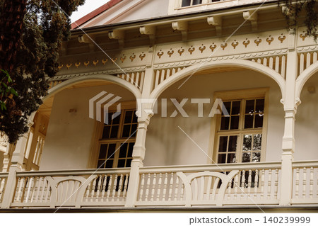 Elegant Historic Wooden Veranda with Decorative Arches and Balustrades Elegant Historic Wooden Veranda with Decorative Arches and Balustrades 140239999