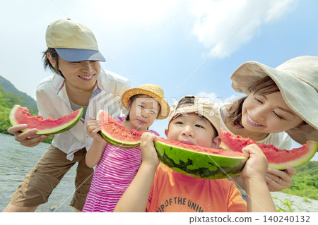 夏天,一家四口在河邊吃西瓜。 夏天,一家四口在河邊吃西瓜。 140240132