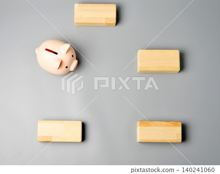 A piggy bank and wooden blocks, designed to evoke images of wealth building and household budget management. A piggy bank and wooden blocks, designed to evoke images of wealth building and household budget management. 140241060